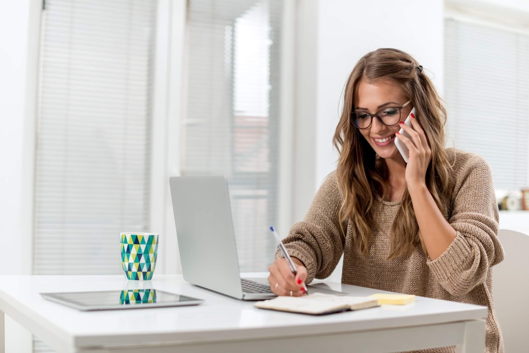 women on the desk with laptop and phone 